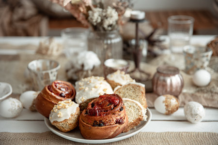 Fresh homemade Easter baked goods on the holiday table with decor details on blurred background.