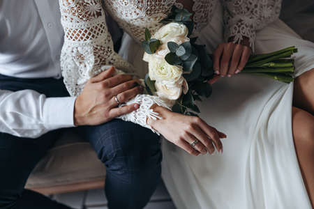 Close up of wedding rings on the fingers of the bride and groom. Wedding photo session.の写真素材