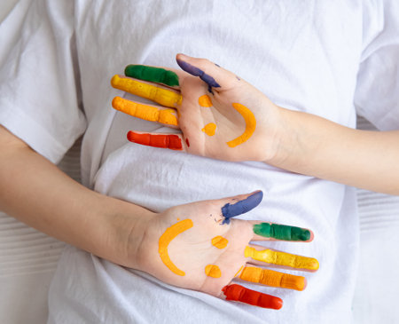 Painted smiles on the palms of a child. Children's creativity and art.の写真素材