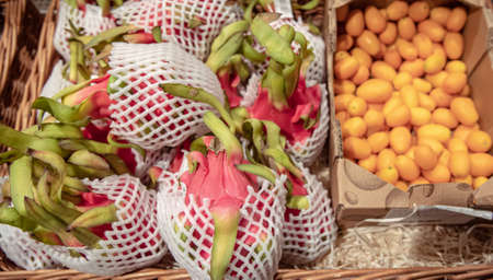 Close up of dragon fruit and kinkan on a supermarket counter.の写真素材