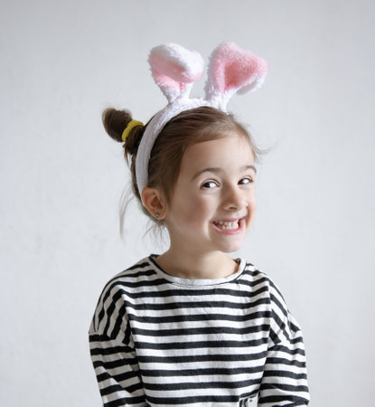 Cheerful little girl with decorative Easter bunny ears on her head.の写真素材