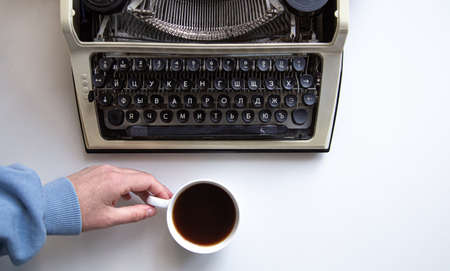Flat lay composition with a typewriter, a cup of coffee and a woman's hand.の写真素材