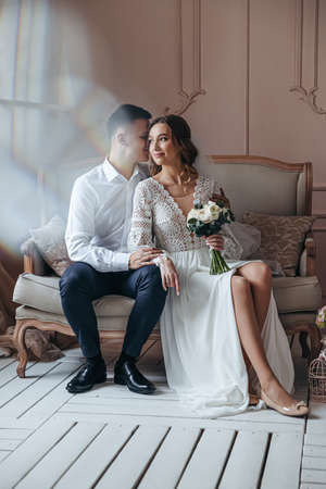 Gentle portrait of the bride and groom in a lace wedding dress in boho style. Wedding photo session in the studio.の写真素材