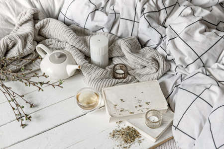 Cozy home composition with a cup of herbal tea and books on a wooden surface.の写真素材