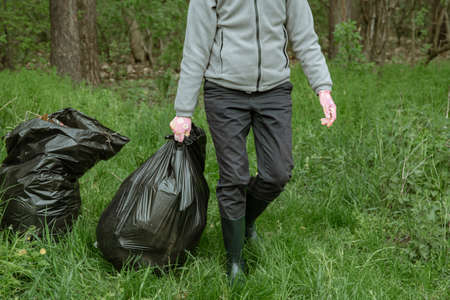 Volunteer with garbage bags on a trip to nature, cleaning the environment.の写真素材