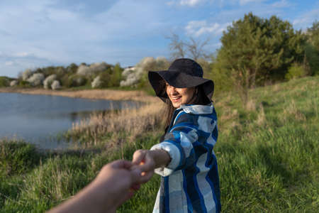 Attractive girl in a hat at sunset on a walk by the lake.の写真素材