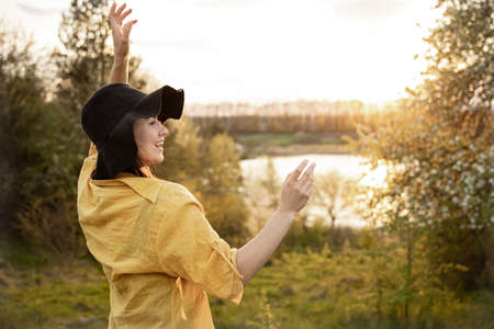 Stylish girl in casual style smiles and looks at the sunset.の写真素材