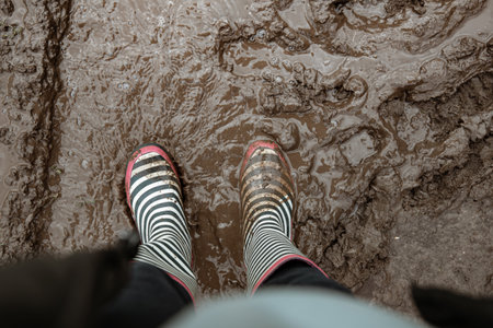 Close-up of rubber boots in a swamp after rain.の写真素材