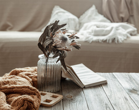 Composition with a book, a dry flower and a knitted element in the interior of the room.の写真素材