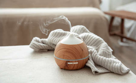 Essential oil aroma diffuser humidifier diffusing water articles in the air copy space.の写真素材