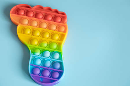 Colorful antistress sensory pop  toys in form of foot on blue background.の写真素材