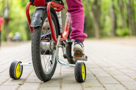 Close-up of a child rides a bicycle with three wheels.の写真素材