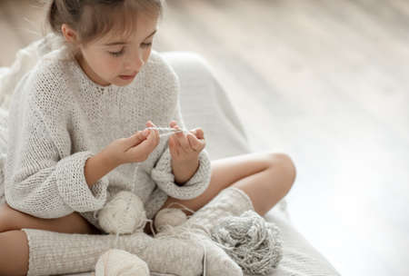 Little girl with a lace napkin from natural cotton yarn, crochet by hand. Crochet as a hobby.の写真素材