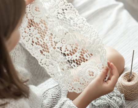 Little girl with a lace napkin from natural cotton yarn, crochet by hand. Crochet as a hobby.の写真素材
