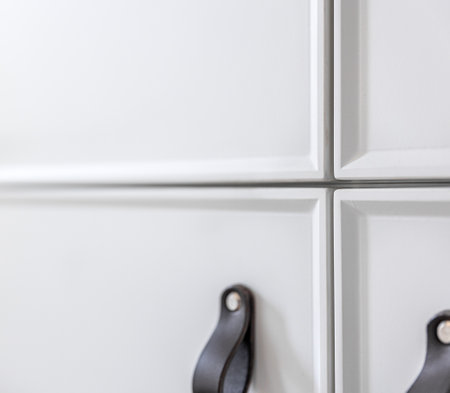 Close up of minimalistic white furniture with black handles, kitchen cabinet, details.の写真素材