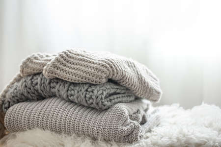 Close-up of a stack of knitted sweaters on a blurred background.の写真素材