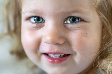 Portrait of a little girl with big blue eyes, tear-stained eyes of a child.