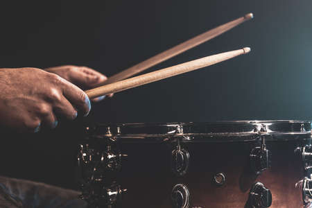 A man plays with sticks on a drum, a drummer plays a percussion instrument, close-up.の写真素材