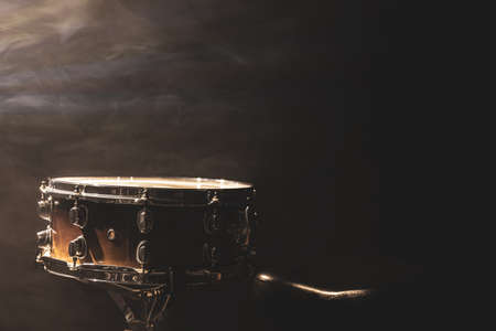 Snare drum on black background, percussion instrument in the dark with stage smoke, copy space.の写真素材