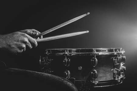 A man plays with sticks on a drum, a drummer plays a percussion instrument, copy space, monochrome.の写真素材