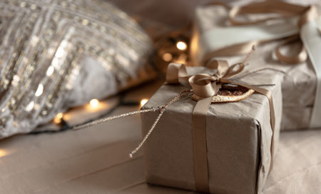 Close-up of a Christmas gift box, decorated with dried flowers and a dry orange, wrapped in craft...