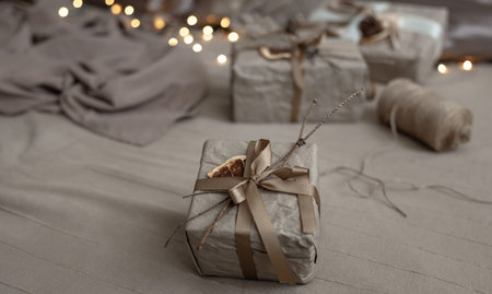 Close-up of a Christmas gift box, decorated with dried flowers and a dry orange, wrapped in craft...