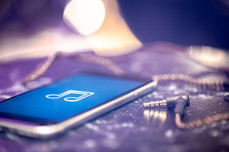 Music background with a music listening icon on the phone and headphones.の写真素材