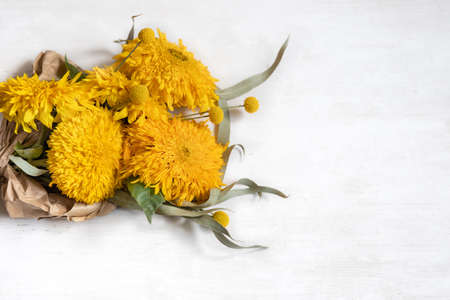 Festive white background with sunflowers and craspedia flowers, copy space.の写真素材