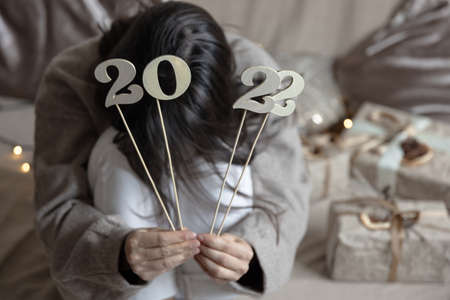 Woman holding numbers 2022 on sticks in her hands, blurred background.の写真素材