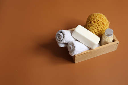 Minimalistic spa composition with soap, washcloth, sea salt and towels in a wooden box, copy space.の写真素材
