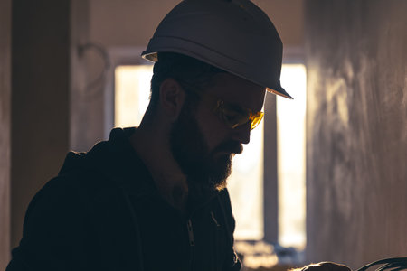 Portrait of a male builder in a protective helmet and goggles.