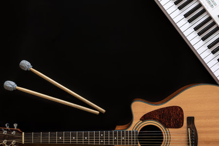 Musical background with guitar, piano, drum sticks and a cup of coffee.