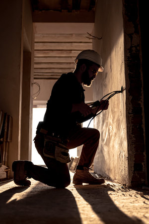 Worker is cutting wires with linemans pliers.