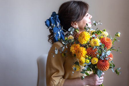 A young woman holds a bouquet of chrysanthemums flowers.