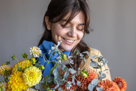 A young woman holds a bouquet of chrysanthemums flowers.