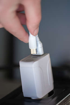 White USB charging for gadgets on a blurred background of the room, close-up.の写真素材