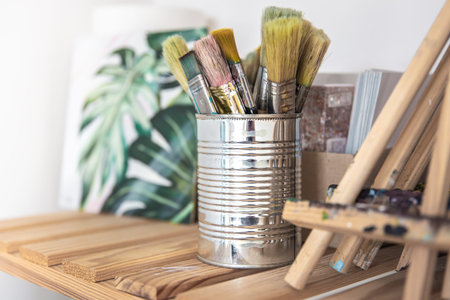 A set of brushes for painting in a tin can on a shelf in the workshop.の写真素材