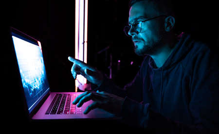 A man analyzing stock market charts, financial data on an electronic board.の写真素材