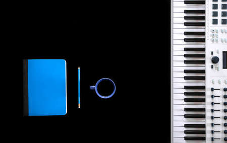 Music keys, notepad and microphone on black background, flat lay.の写真素材