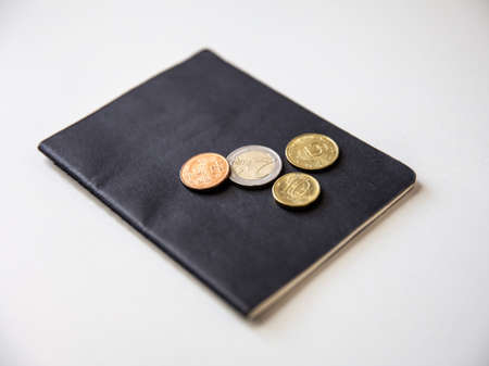 Close up of passport and coins on a white background.の写真素材