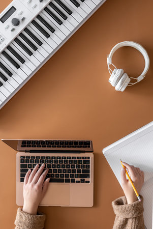Musical background with musical keys, laptop and female hands.