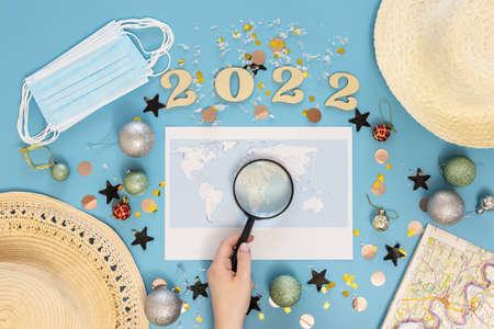 Travel flat lay composition with world map and numbers 2022 on blue background.の写真素材