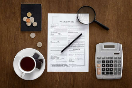 Visa application form on a wooden table, visa processing, registration, flat layの写真素材