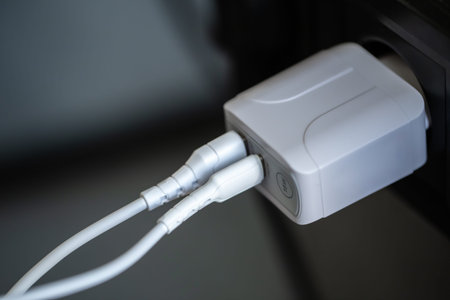 White USB charging for gadgets on a blurred background of the room, close-up.
