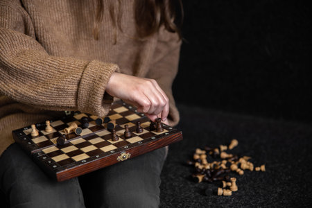 Woman placing chess pieces on a chessboard, copy space.