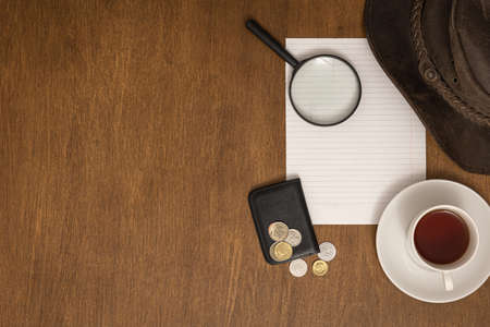 White sheet, money, magnifier and coffee on a wooden table, flat lay.の写真素材