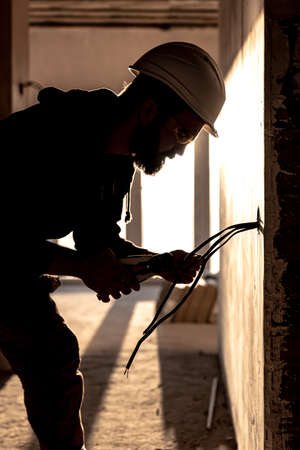 Worker is cutting wires with linemans pliers.の写真素材