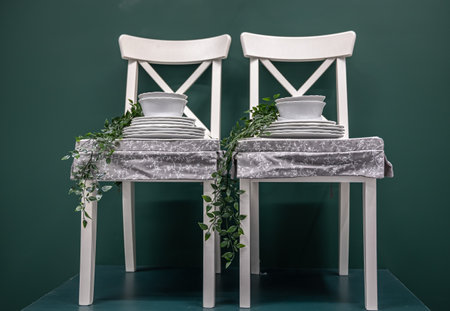 Kitchen composition with a set of dishes on white chairs.の写真素材
