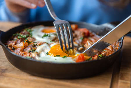 Close-up, a woman in a cafe dines on traditional shakshuka.の写真素材