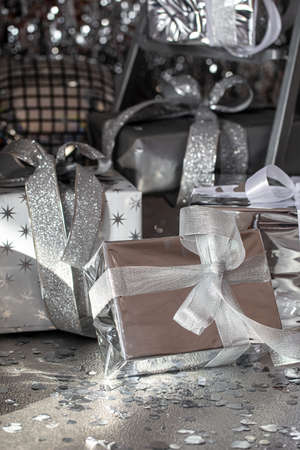 Silver festive Christmas boxes on a shiny background.の写真素材